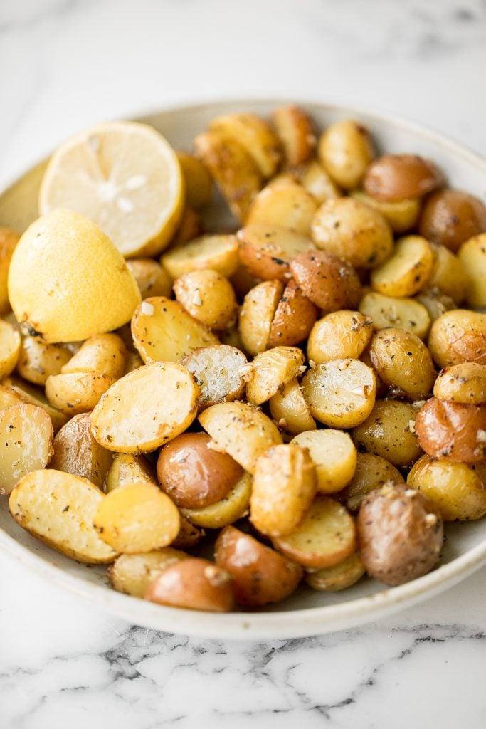 Quick and easy Greek lemon roasted baby potatoes are crispy on the outside and tender inside, packed with a Greek flavour blend of lemon, garlic and herbs. | aheadofthyme.com