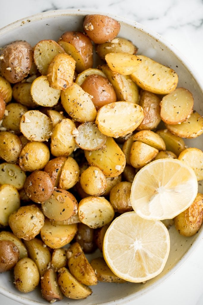 Quick and easy Greek lemon roasted baby potatoes are crispy on the outside and tender inside, packed with a Greek flavour blend of lemon, garlic and herbs. | aheadofthyme.com