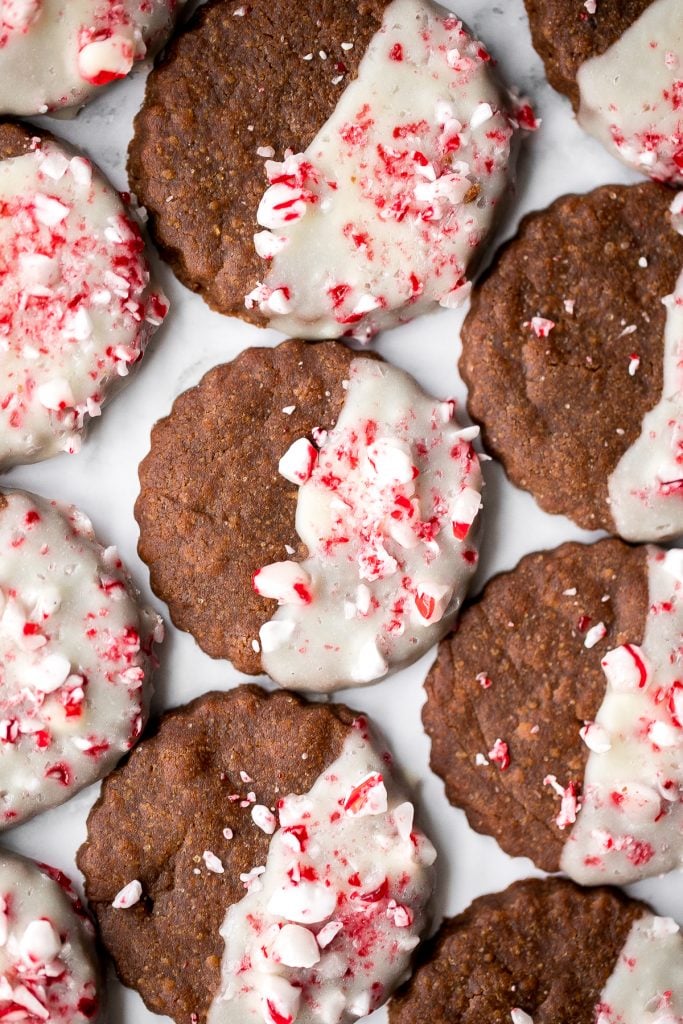 Festive white chocolate peppermint gingerbread cookies are soft and chewy, dipped in white chocolate, with a sprinkle of crushed peppermint candy canes. | aheadofthyme.com