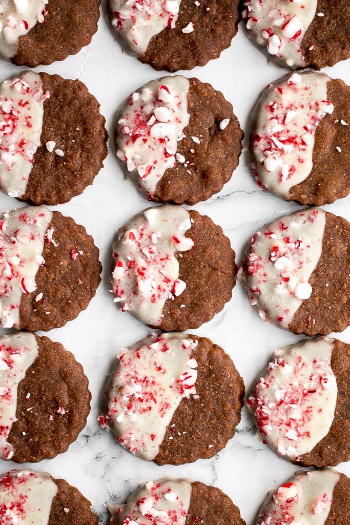 Festive white chocolate peppermint gingerbread cookies are soft and chewy, dipped in white chocolate, with a sprinkle of crushed peppermint candy canes. | aheadofthyme.com