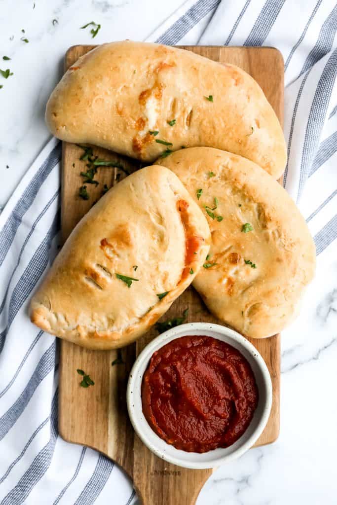 Homemade calzones are delicious little pizza pockets filled with cheese and toppings and baked until golden. This Italian favourite is easy to make at home. | aheadofthyme.com