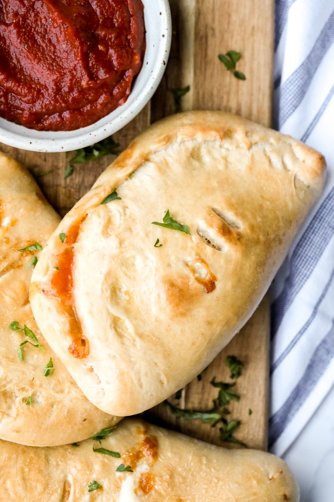 Homemade calzones are delicious little pizza pockets filled with cheese and toppings and baked until golden. This Italian favourite is easy to make at home. | aheadofthyme.com