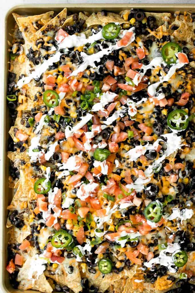 Oven-baked loaded sheet pan nachos are a crowd pleaser for an easy weeknight dinner or an addicting appetizer to serve on game day. | aheadofthyme.com