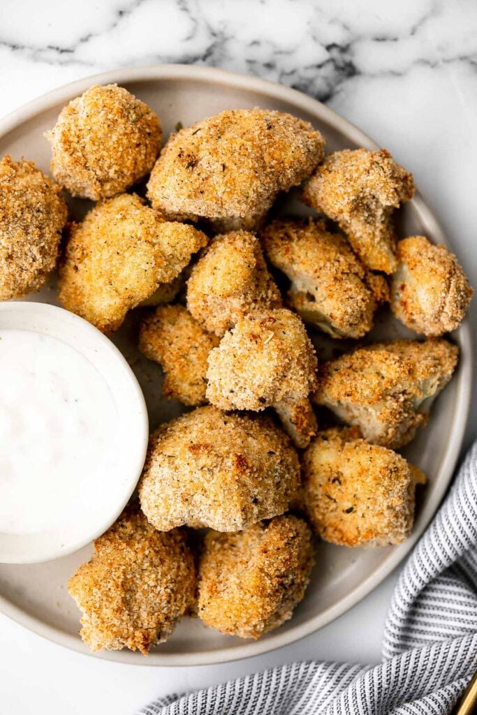Healthy baked cauliflower nuggets are a vegetarian alternative to chicken nuggets. With parmesan panko breading, these bites are baked until crispy. | aheadofthyme.com