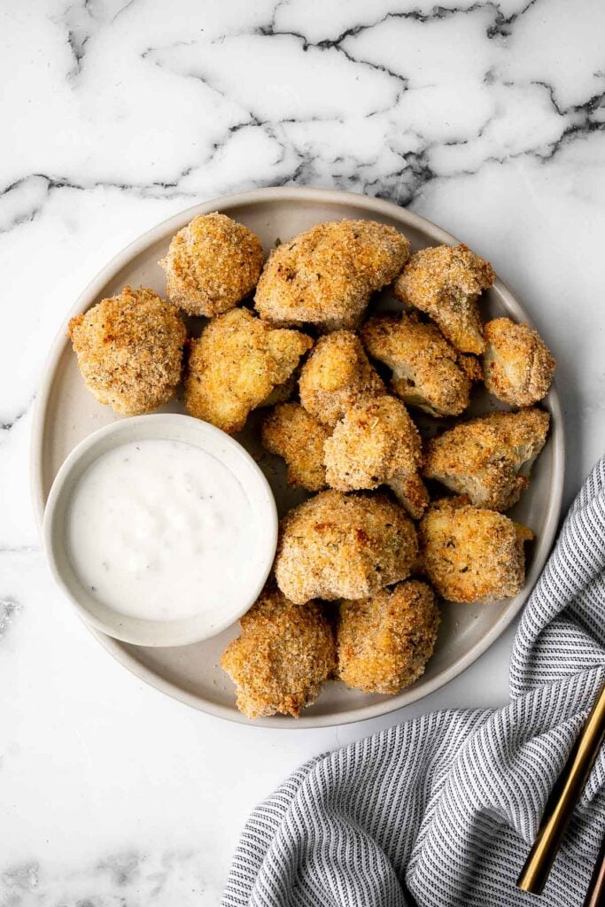 Healthy baked cauliflower nuggets are a vegetarian alternative to chicken nuggets. With parmesan panko breading, these bites are baked until crispy. | aheadofthyme.com