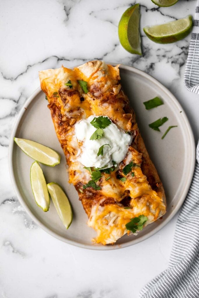 Easy baked chicken enchiladas brings the taste of authentic Mexican food into your kitchen -- saucy, spicy, and savoury. Perfect for a Mexican fiesta. | aheadofthyme.com