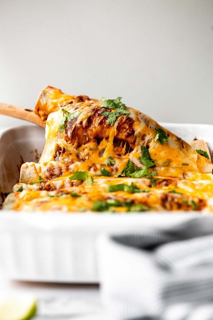 Easy baked chicken enchiladas brings the taste of authentic Mexican food into your kitchen -- saucy, spicy, and savoury. Perfect for a Mexican fiesta. | aheadofthyme.com