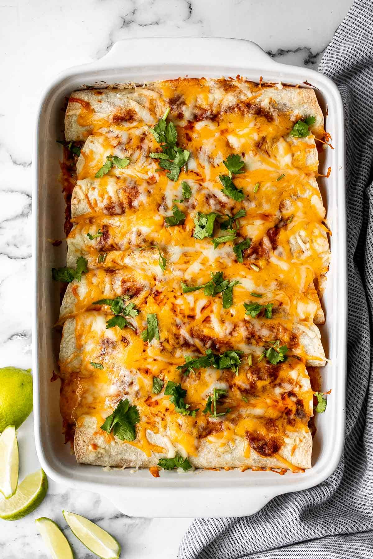 Easy baked chicken enchiladas brings the taste of authentic Mexican food into your kitchen -- saucy, spicy, and savoury. Perfect for a Mexican fiesta. | aheadofthyme.com