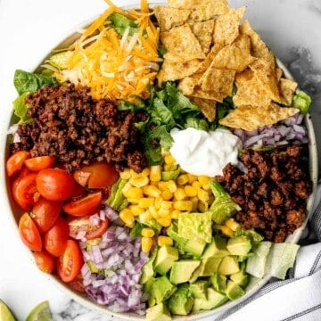 Beef taco salad is a simple, filling, and delicious meal loaded with your favorite taco fillings, and a creamy lime dressing. Make it in 20 minutes. | aheadofthyme.com