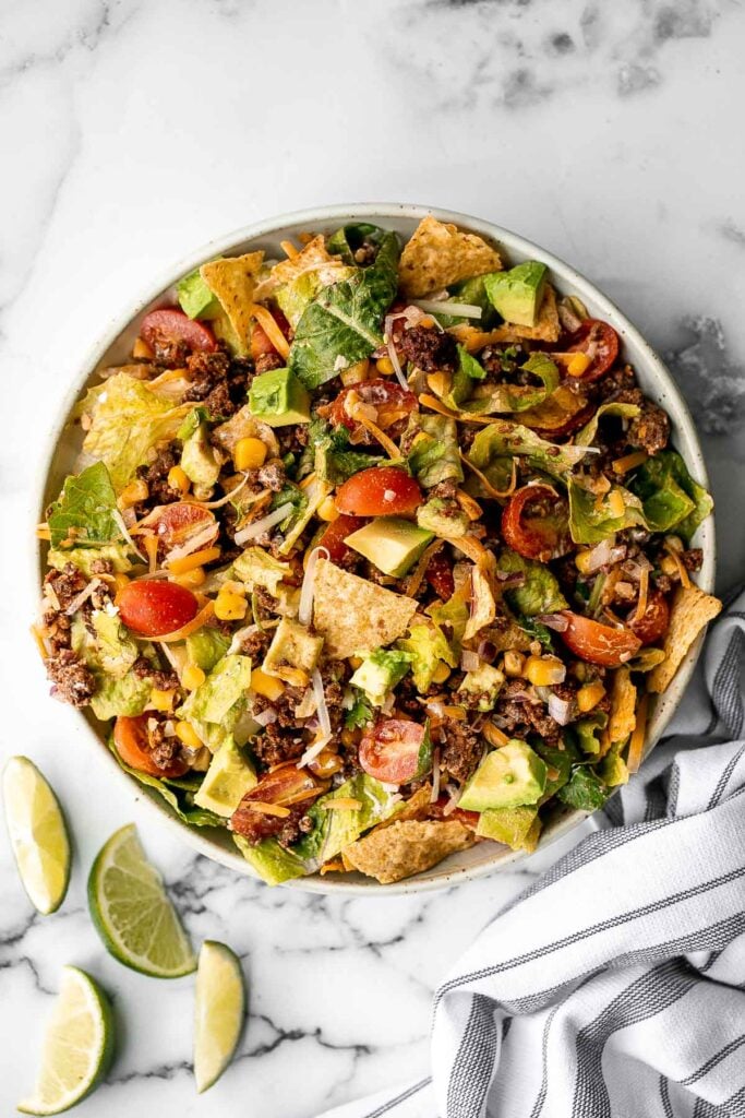 Beef taco salad is a simple, filling, and delicious meal loaded with your favorite taco fillings, and a creamy lime dressing. Make it in 20 minutes. | aheadofthyme.com