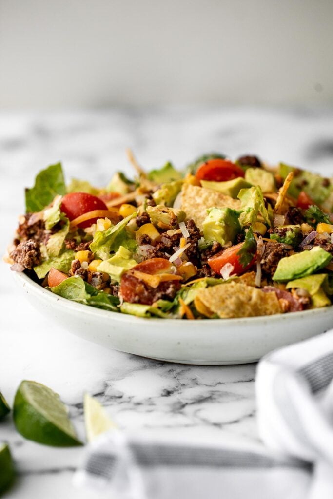 Beef taco salad is a simple, filling, and delicious meal loaded with your favorite taco fillings, and a creamy lime dressing. Make it in 20 minutes. | aheadofthyme.com