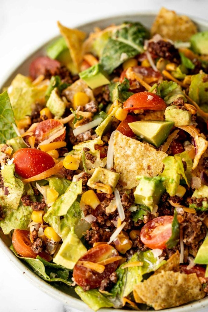 Beef taco salad is a simple, filling, and delicious meal loaded with your favorite taco fillings, and a creamy lime dressing. Make it in 20 minutes. | aheadofthyme.com