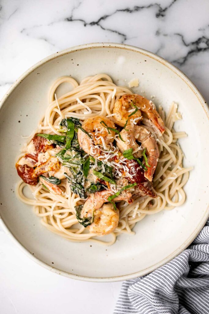 Creamy Tuscan shrimp packed with sun-dried tomatoes, spinach, and garlic, is creamy, rich, and delicious. Make it in just 15 minutes, including prep! | aheadofthyme.com