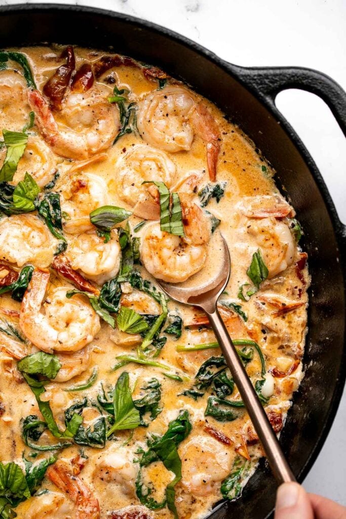 Creamy Tuscan shrimp packed with sun-dried tomatoes, spinach, and garlic, is creamy, rich, and delicious. Make it in just 15 minutes, including prep! | aheadofthyme.com