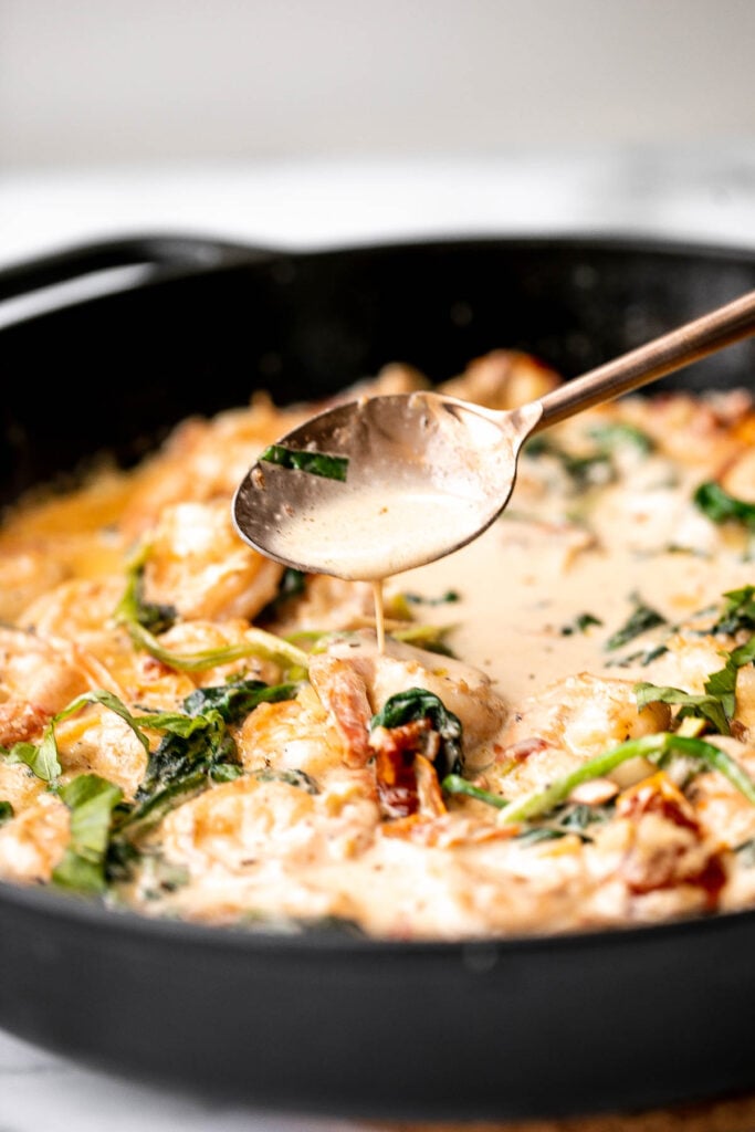 Creamy Tuscan shrimp packed with sun-dried tomatoes, spinach, and garlic, is creamy, rich, and delicious. Make it in just 15 minutes, including prep! | aheadofthyme.com