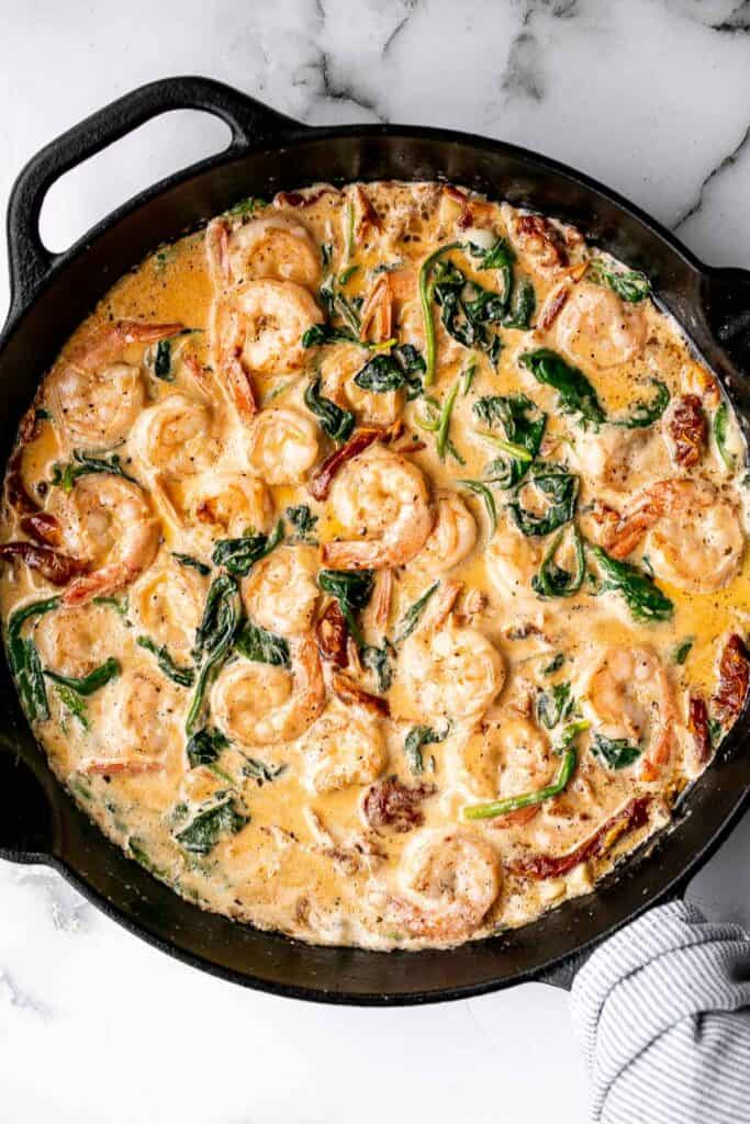 Creamy Tuscan shrimp packed with sun-dried tomatoes, spinach, and garlic, is creamy, rich, and delicious. Make it in just 15 minutes, including prep! | aheadofthyme.com