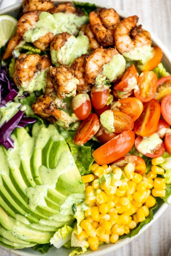 Shrimp taco salad with cilantro lime dressing is flavourful, delicious, and easy to make. It has all the fixings and of shrimp tacos, but without the mess. | aheadofthyme.com