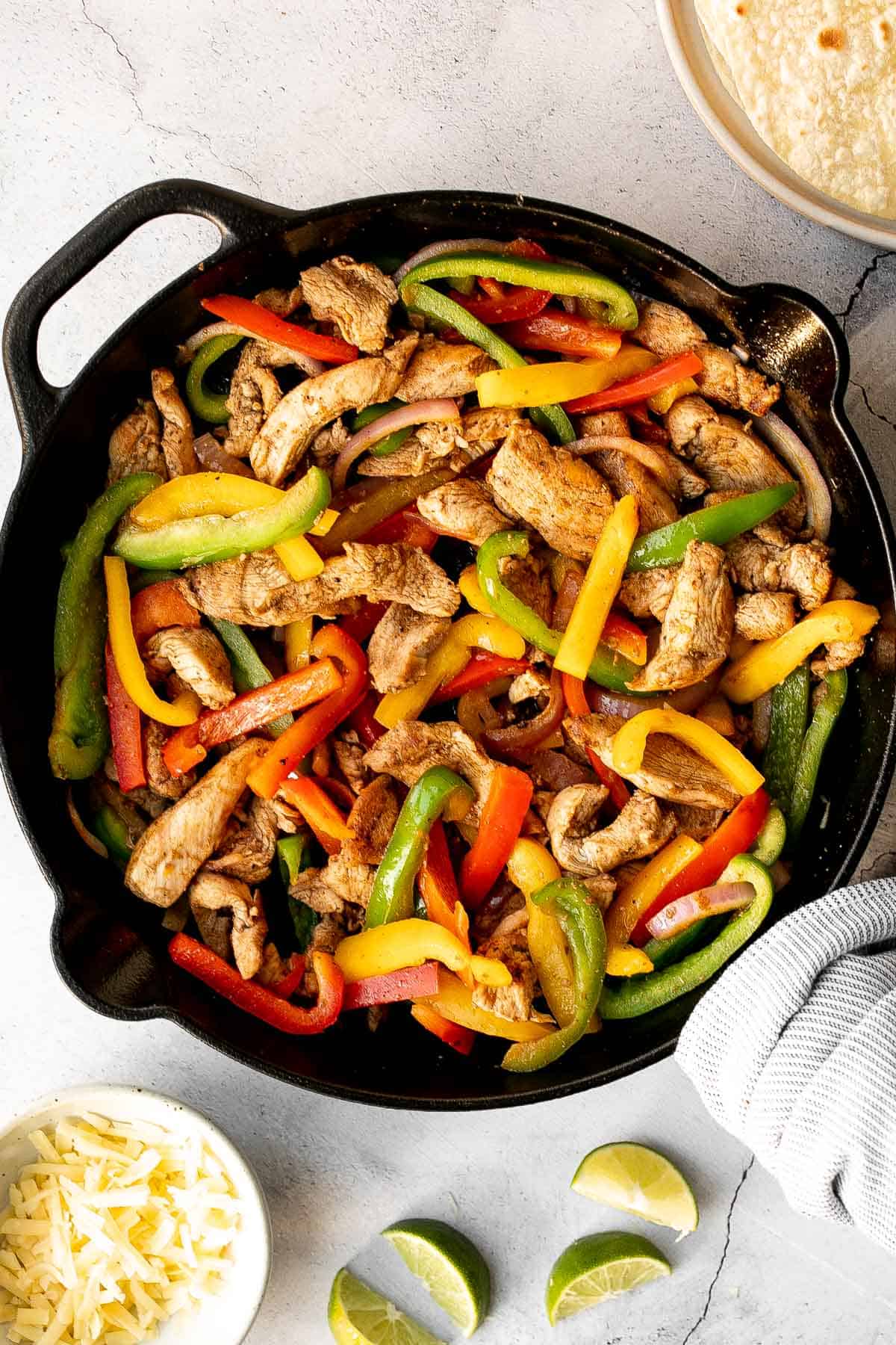 Skillet chicken fajitas are a light, fresh, and sizzling dish bursting with flavour, packed with colorful vegetables, and wrapped in warm tortillas. | aheadofthyme.com