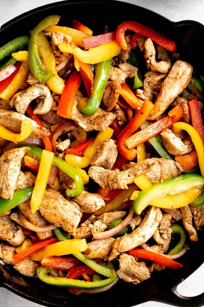Skillet chicken fajitas are a light, fresh, and sizzling dish bursting with flavour, packed with colorful vegetables, and wrapped in warm tortillas. | aheadofthyme.com