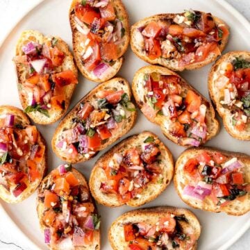 Tomato bruschetta with balsamic glaze is an easy Italian appetizer topped with tomatoes, onions, garlic, basil and olive oil. Delicious, fresh and simple. | aheadofthyme.com