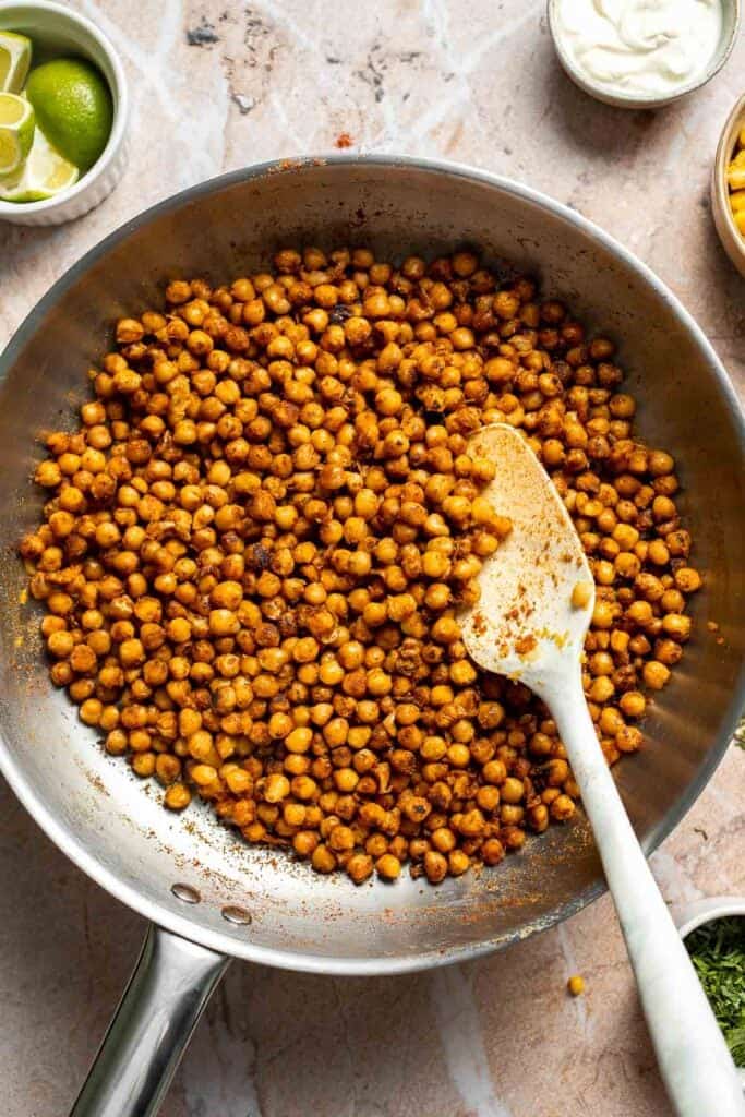 Seasoned chickpeas cooking until evenly coated with taco spices.