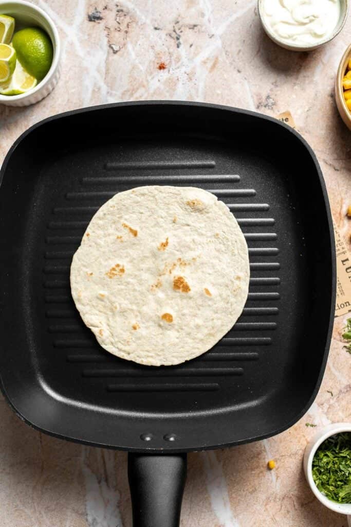 Small tortilla warming in a grill pan.