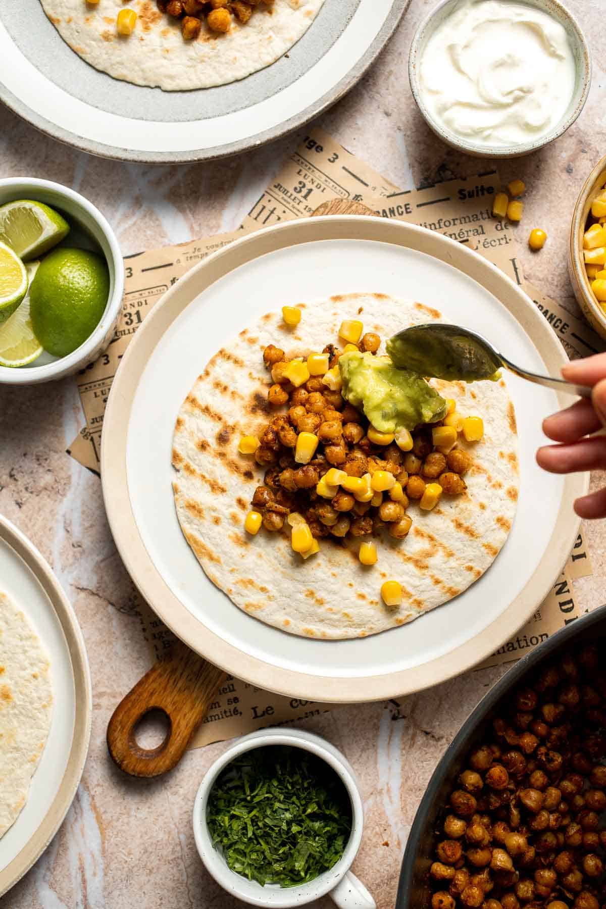 Guacamole being spooned onto a chickpea taco.