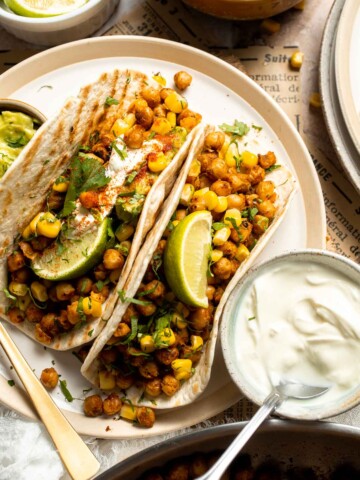Healthy vegan chickpea tacos with seasoned chickpeas, guacamole, corn, cilantro, and lime. Easy plant-based taco recipe.