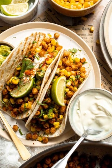 Healthy vegan chickpea tacos with seasoned chickpeas, guacamole, corn, cilantro, and lime. Easy plant-based taco recipe.