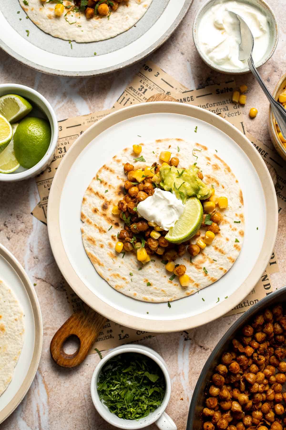 Finished chickpea taco topped with guacamole, corn, and cilantro.