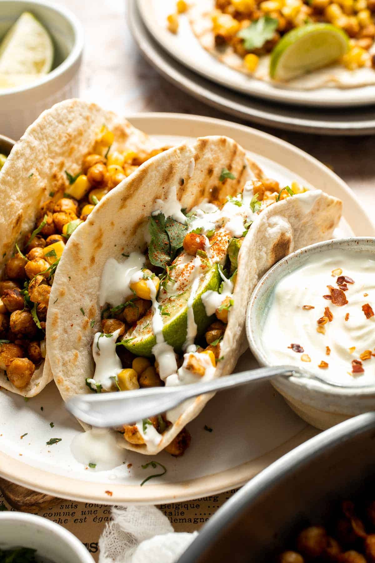 Healthy vegan chickpea tacos filled with seasoned chickpeas, guacamole, corn, and fresh cilantro.