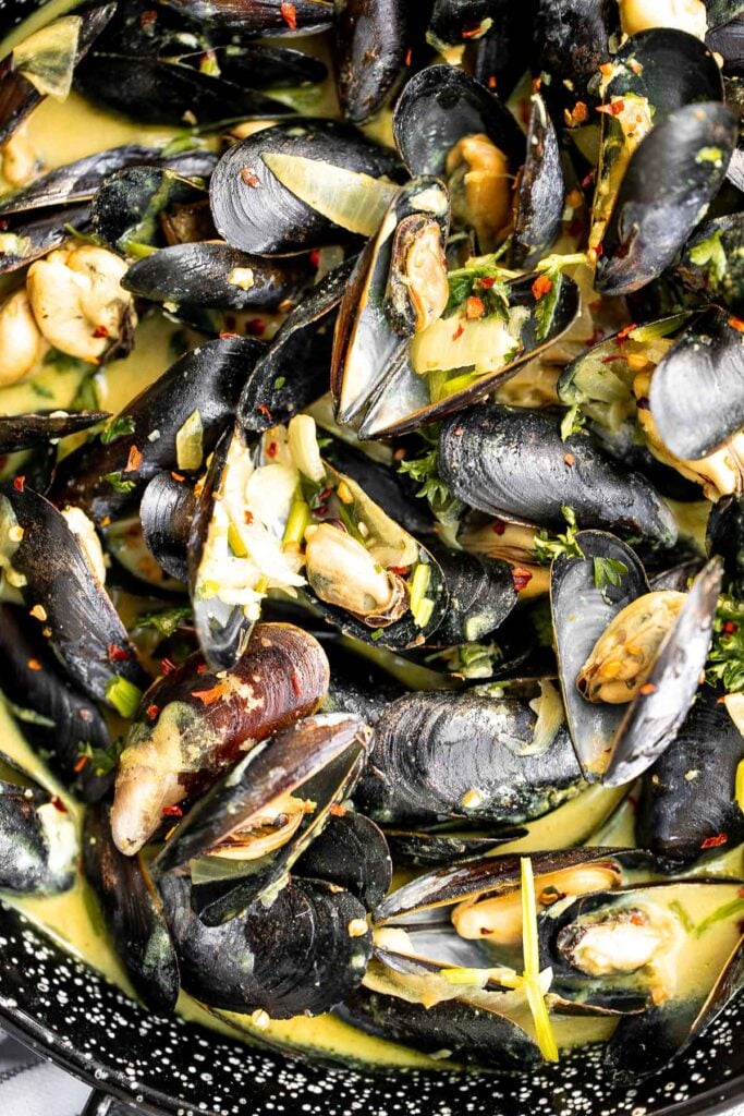 Yellow curry mussels are the epitome of delicious seafood - creamy, spicy, and savory. This flavourful one pot dish is quick + easy to make in 25 minutes. | aheadofthyme.com