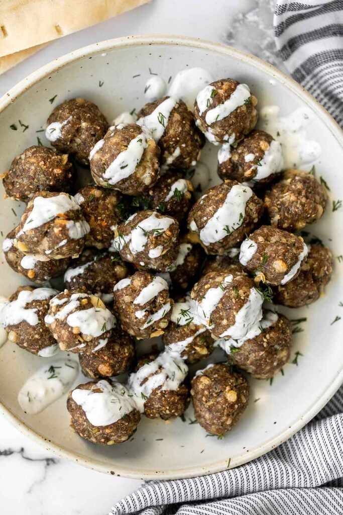 Baked Greek meatballs are juicy, tender, flavorful, and delicious. They are quick and easy to make in 30 minutes, and freezer-friendly. Serve with tzatziki. | aheadofthyme.com