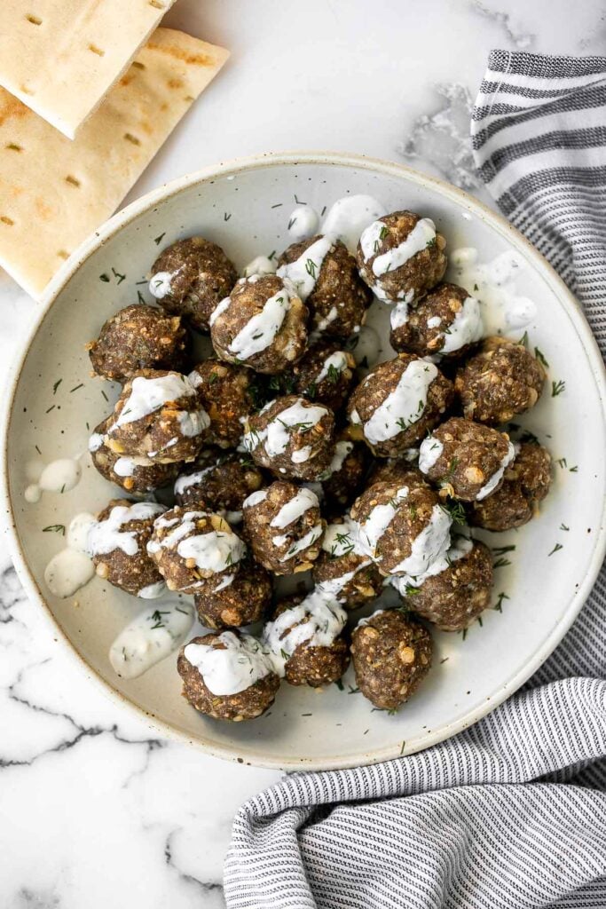 Baked Greek meatballs are juicy, tender, flavorful, and delicious. They are quick and easy to make in 30 minutes, and freezer-friendly. Serve with tzatziki. | aheadofthyme.com