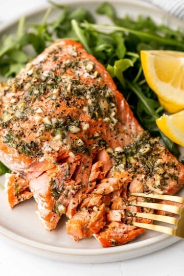 Greek salmon is delicious, flaky, and tender. This healthy oven-baked salmon is packed with Mediterranean flavors and is ready in just 20 minutes. | aheadofthyme.com