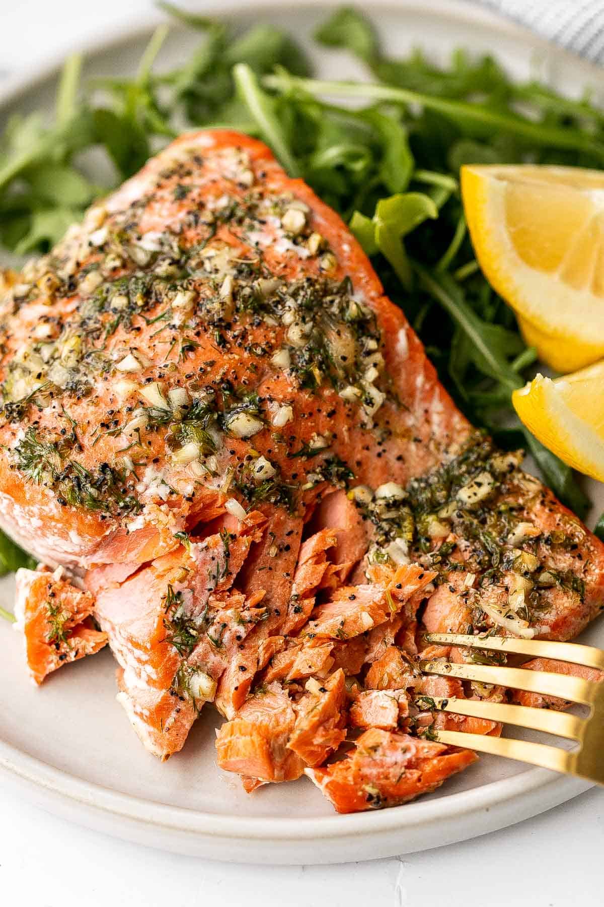 Greek salmon is delicious, flaky, and tender. This healthy oven-baked salmon is packed with Mediterranean flavors and is ready in just 20 minutes. | aheadofthyme.com
