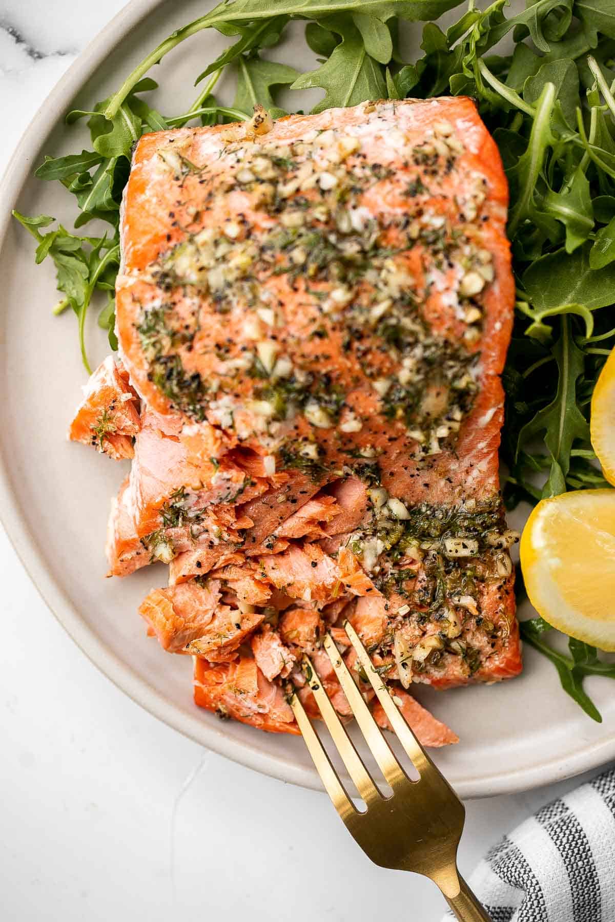 Greek salmon is delicious, flaky, and tender. This healthy oven-baked salmon is packed with Mediterranean flavors and is ready in just 20 minutes. | aheadofthyme.com