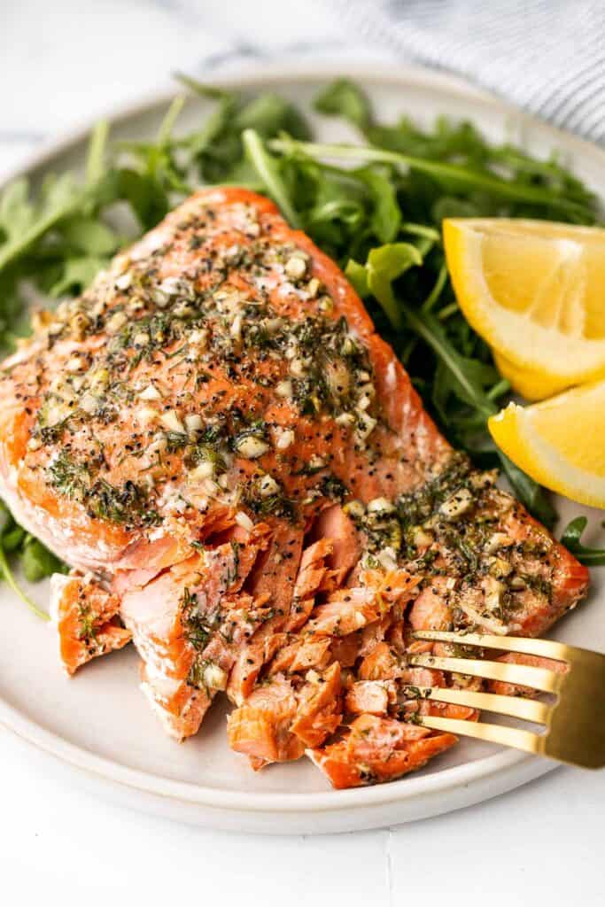 Greek salmon is delicious, flaky, and tender. This healthy oven-baked salmon is packed with Mediterranean flavors and is ready in just 20 minutes. | aheadofthyme.com