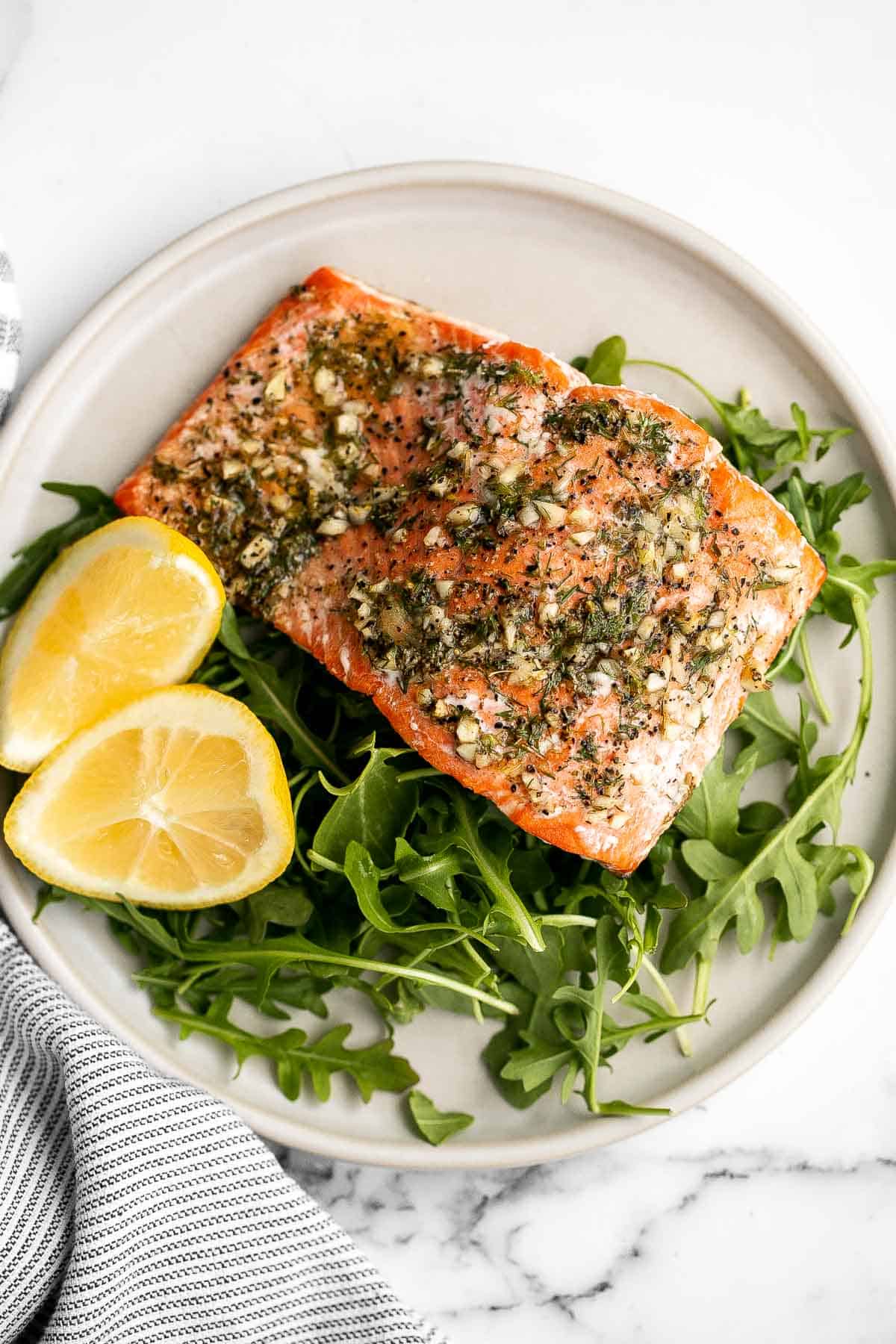 Greek salmon is delicious, flaky, and tender. This healthy oven-baked salmon is packed with Mediterranean flavors and is ready in just 20 minutes. | aheadofthyme.com