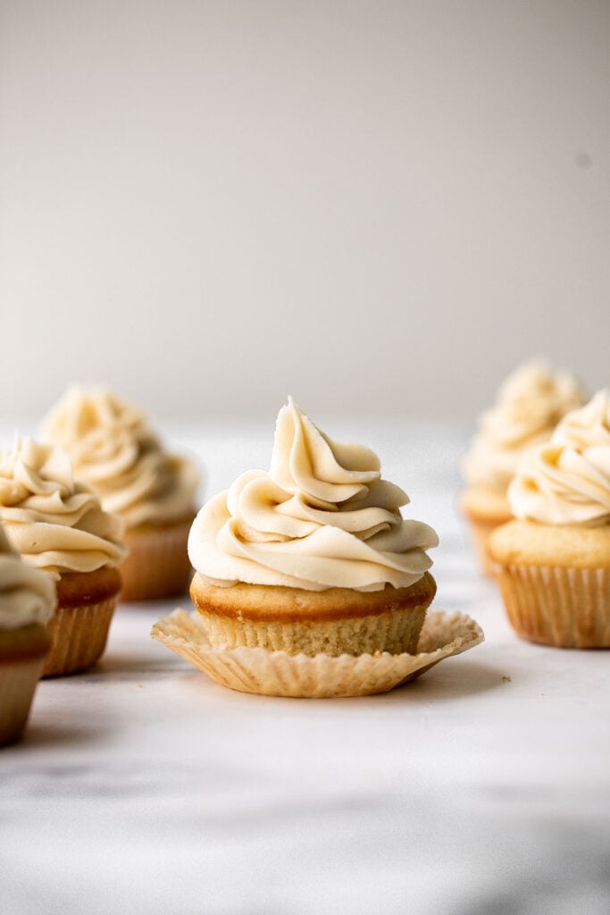 Moist vanilla cupcakes with buttercream frosting are soft, fluffy, simple, sweet, and delicious. Secret ingredient yogurt keeps them moist for days! | aheadofthyme.com