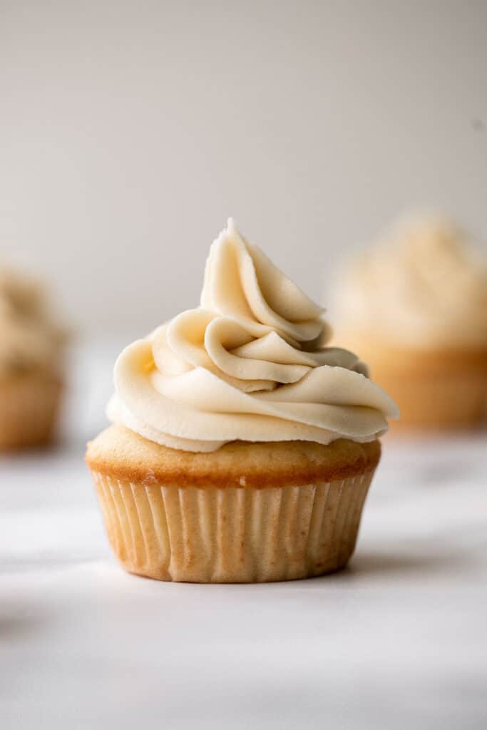 Moist vanilla cupcakes with buttercream frosting are soft, fluffy, simple, sweet, and delicious. Secret ingredient yogurt keeps them moist for days! | aheadofthyme.com
