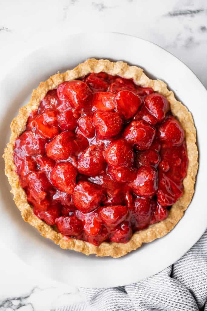 Fresh strawberry pie is a delicious, summer dessert loaded with juicy strawberries and homemade strawberry glaze with no jello, in a flakey pie crust. | aheadofthyme.com