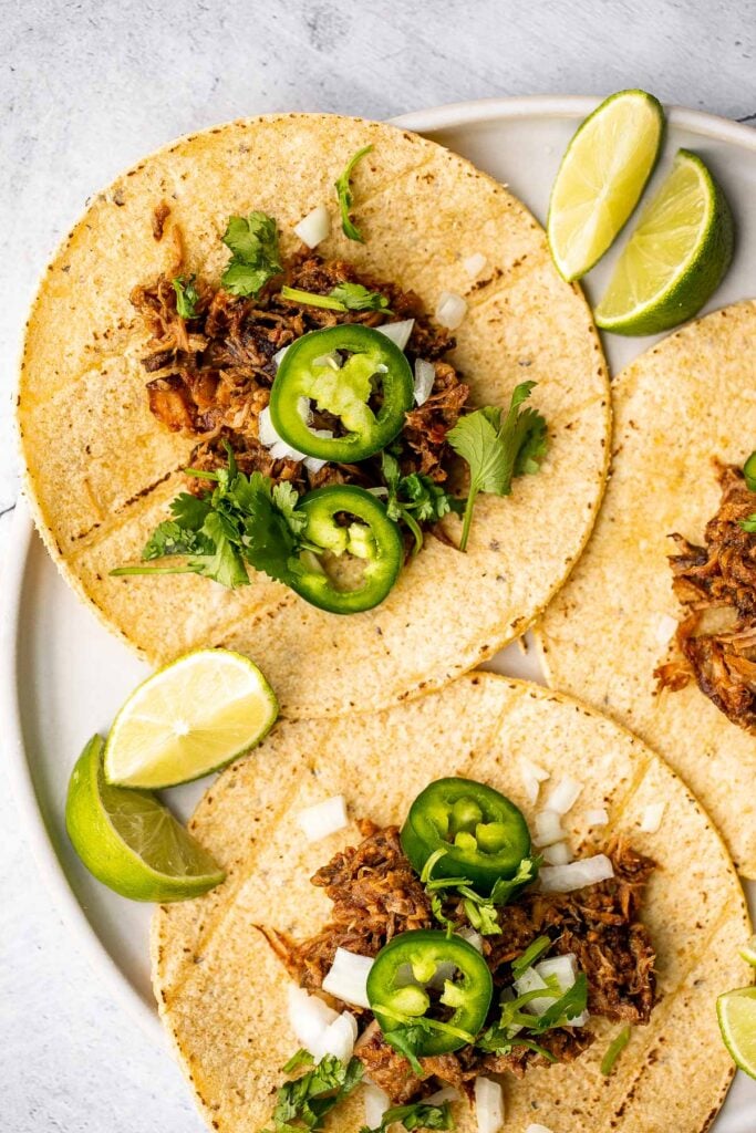 Crispy, shredded slow cooker carnitas (pulled pork) are a Mexican favorite that you can make at home. Packed with flavor, easy to make, and minimal dishes. | aheadofthyme.com