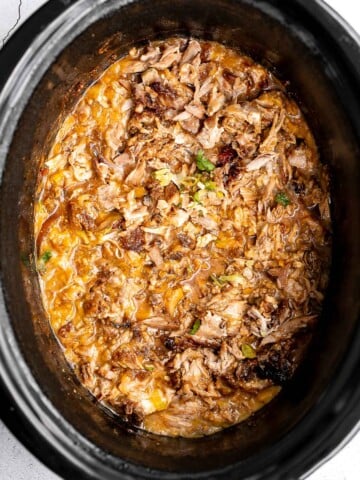 Crispy, shredded slow cooker carnitas (pulled pork) are a Mexican favorite that you can make at home. Packed with flavor, easy to make, and minimal dishes. | aheadofthyme.com