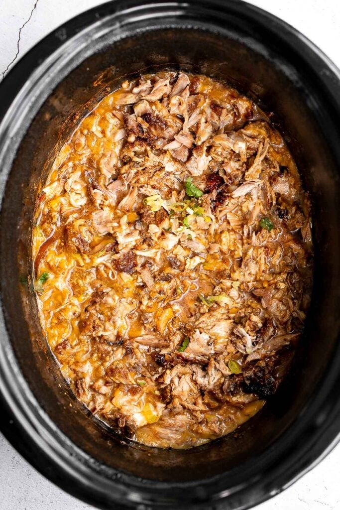 Crispy, shredded slow cooker carnitas (pulled pork) are a Mexican favorite that you can make at home. Packed with flavor, easy to make, and minimal dishes. | aheadofthyme.com