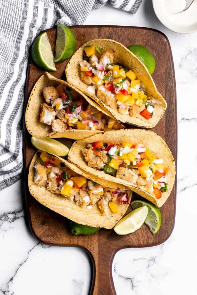 Fish stick tacos are fun, quick, easy, and delicious. Crispy breaded fish sticks are topped with a homemade mango salsa and a drizzle of lime crema. | aheadofthyme.com