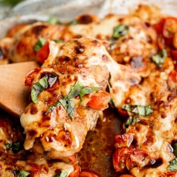 Baked caprese chicken is tender, juicy, and delicious, topped with burst tomatoes, mozzarella cheese, fresh basil, and a drizzle of balsamic glaze. | aheadofthyme.com