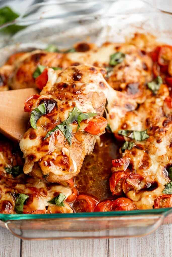 Baked caprese chicken is tender, juicy, and delicious, topped with burst tomatoes, mozzarella cheese, fresh basil, and a drizzle of balsamic glaze. | aheadofthyme.com