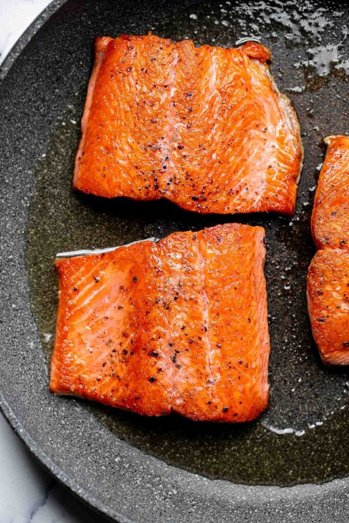 Creamy garlic salmon is a quick easy one-pan meal ready in under 30 minutes, with seared flaky tender salmon tossed in a delicious creamy garlic sauce. | aheadofthyme.com