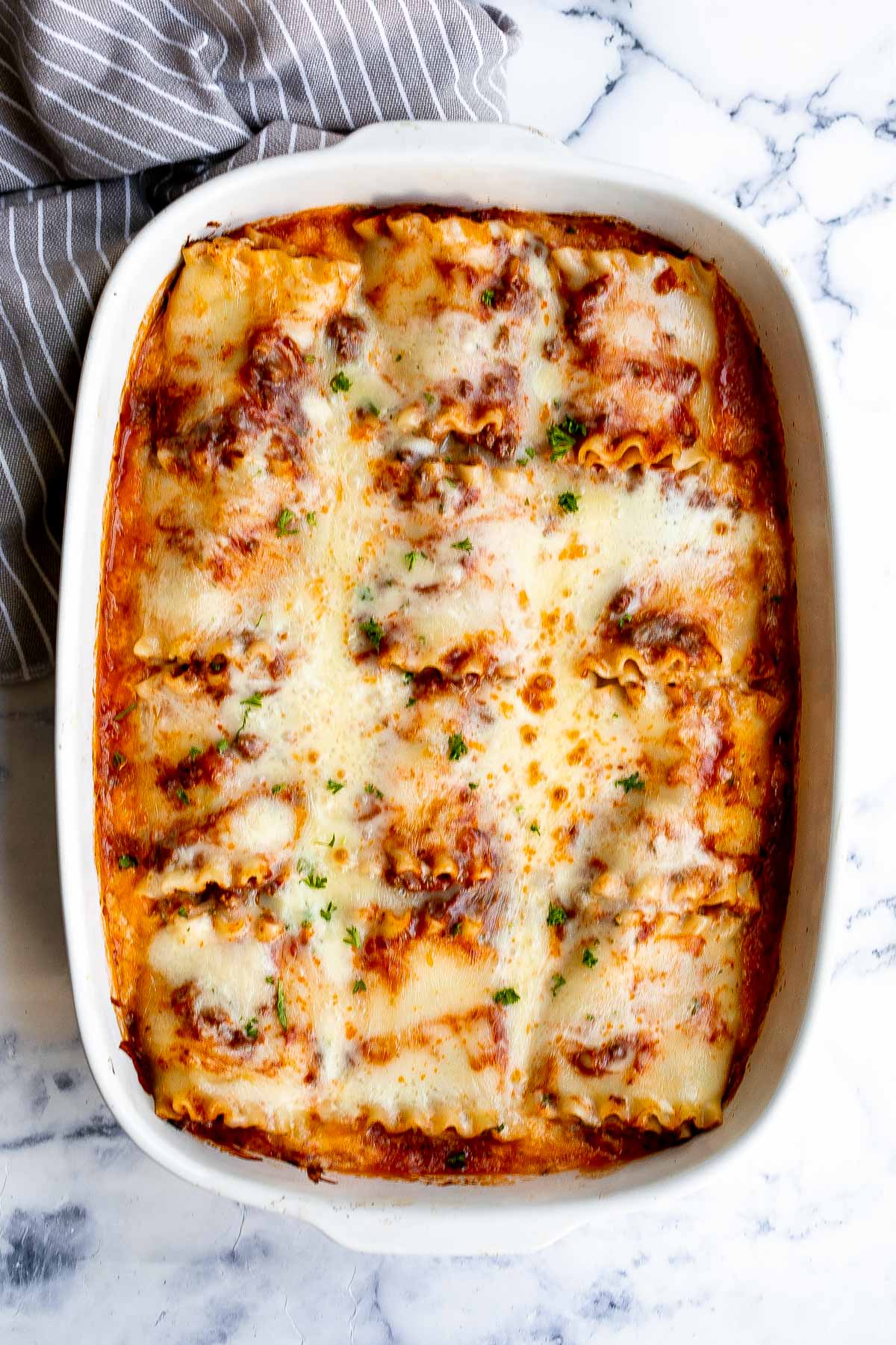Lasagna roll ups are a twist on traditional lasagna. Lasagna noodles are filled with cheese and meat sauce and rolled up. Make ahead and freezer-friendly! | aheadofthyme.com